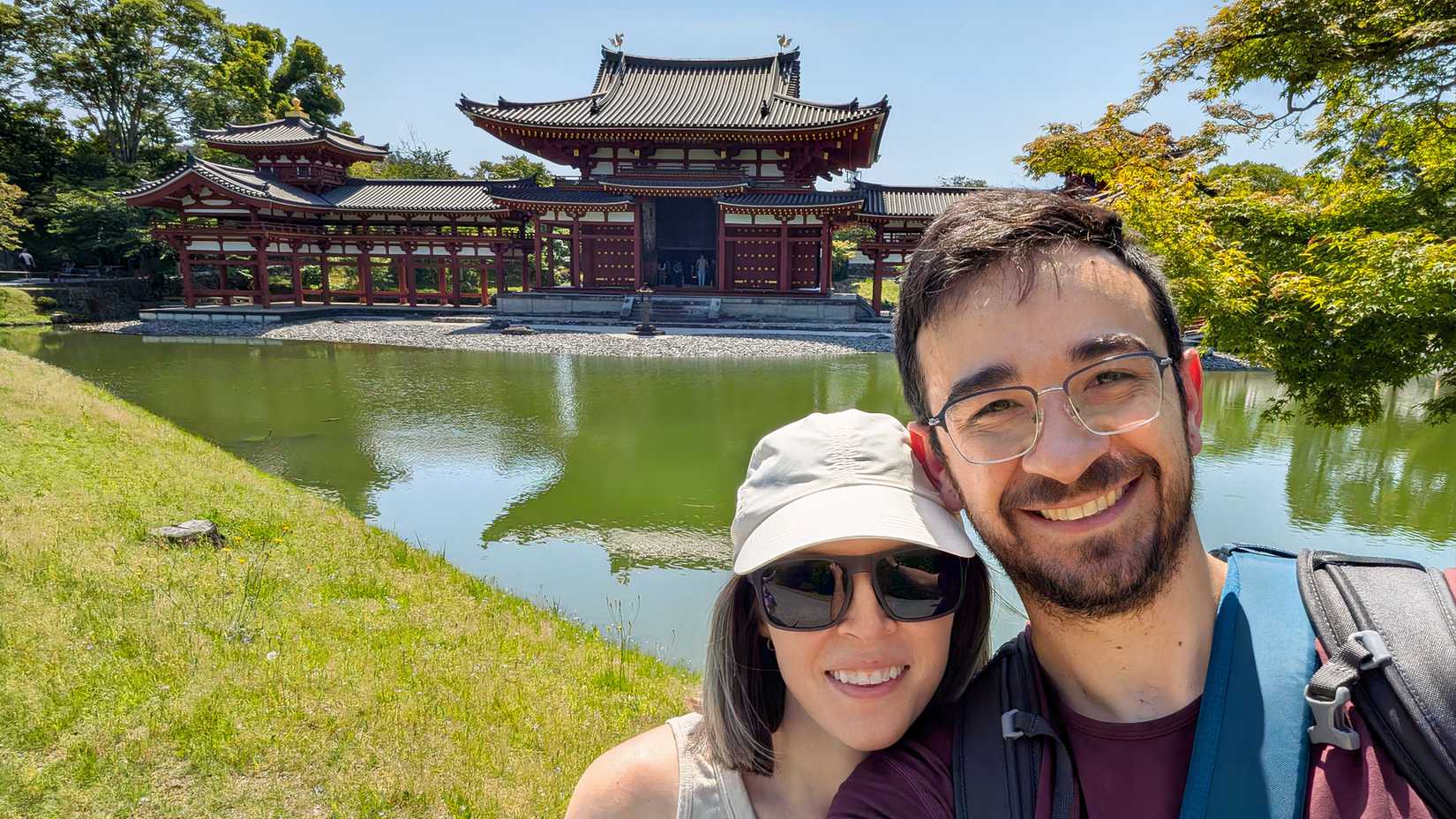 TJ and her husband take a selfie beside a pond and historic Japanese temple while she wears Nerivio on her upper arm.