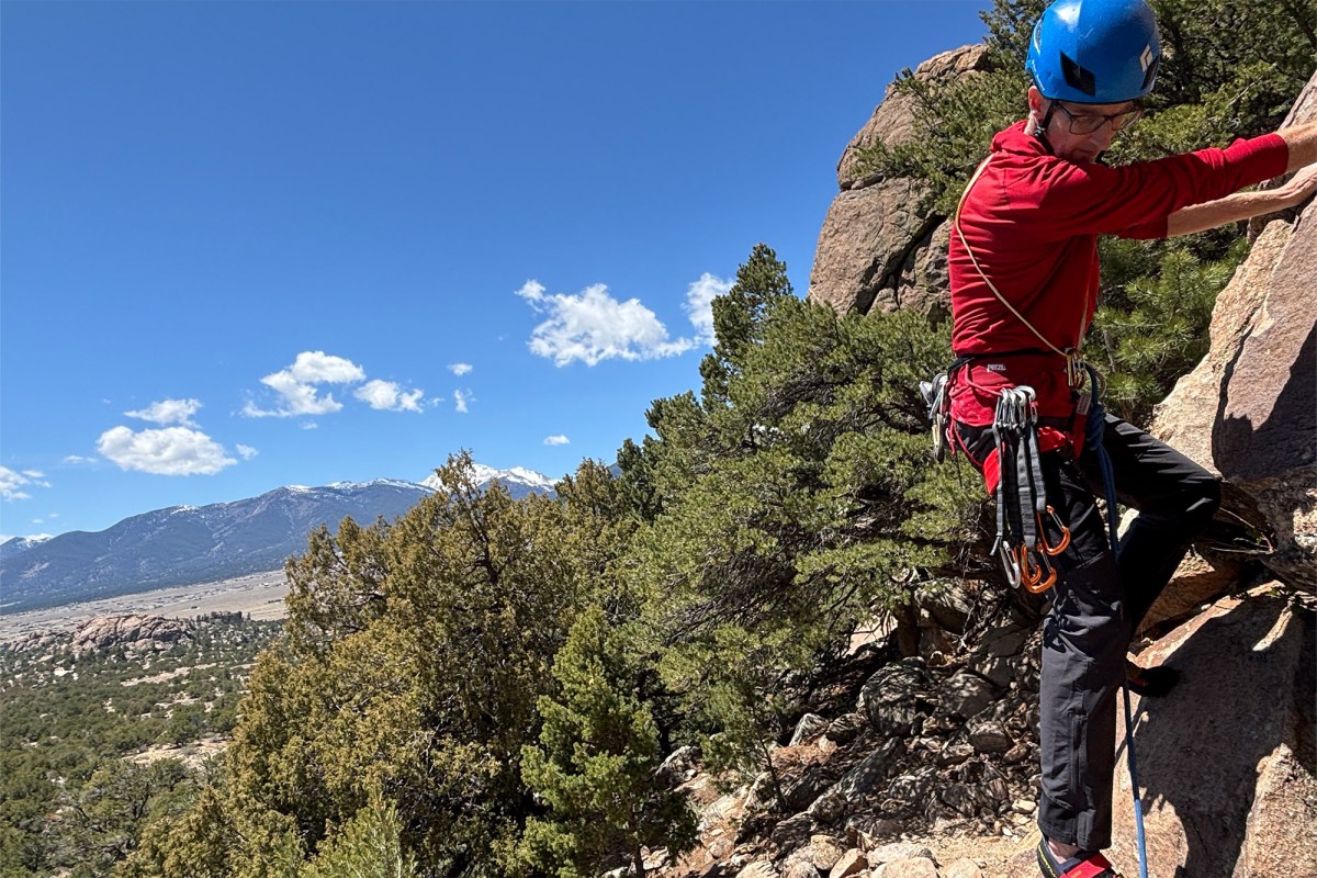 Rock climber wearing a red harness loaded with protection
