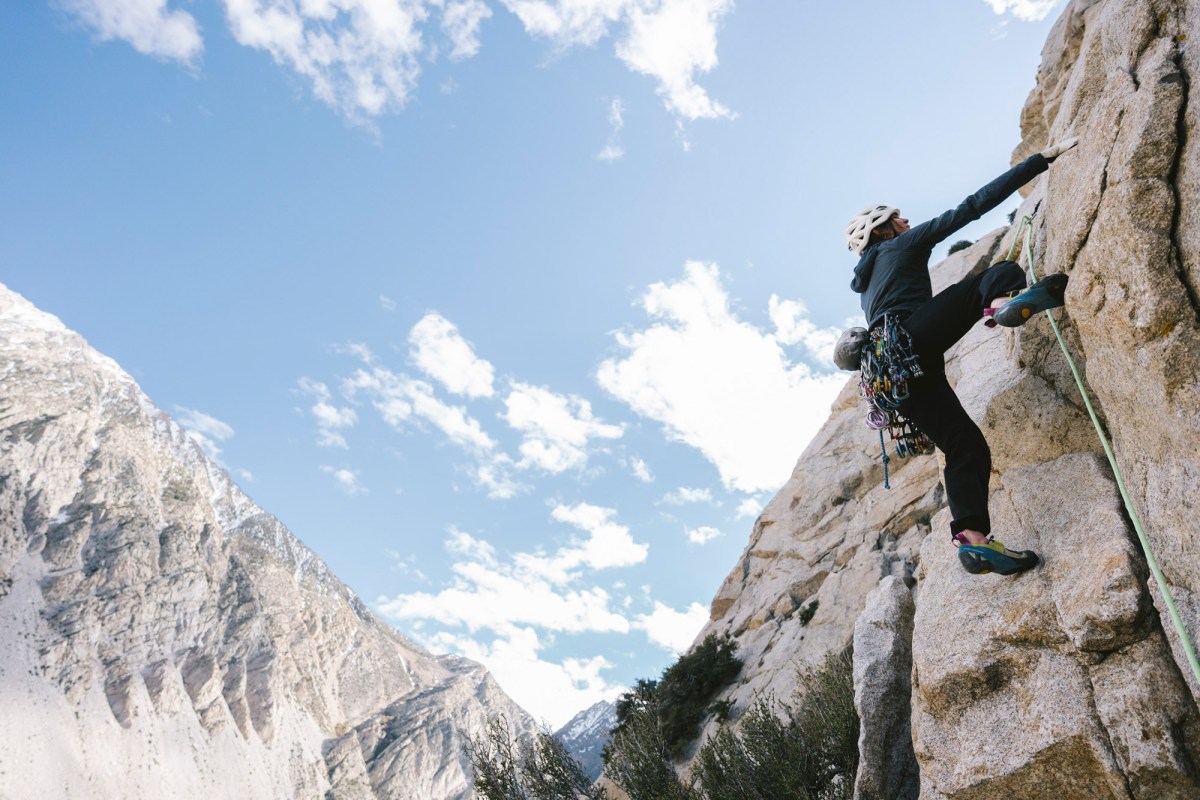 Climber testing Summit Series pants on a steep granite route