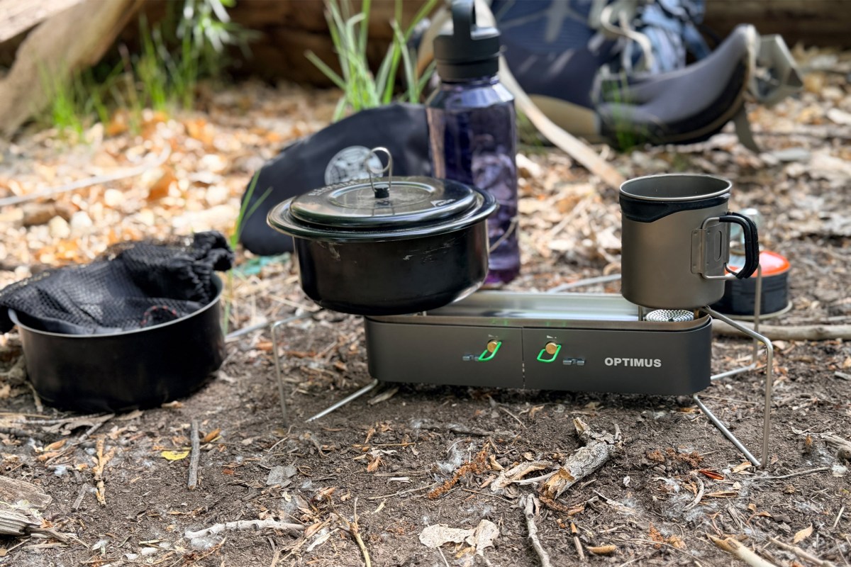 Optimus Gemini II stove heating a pot and mug at a campsite