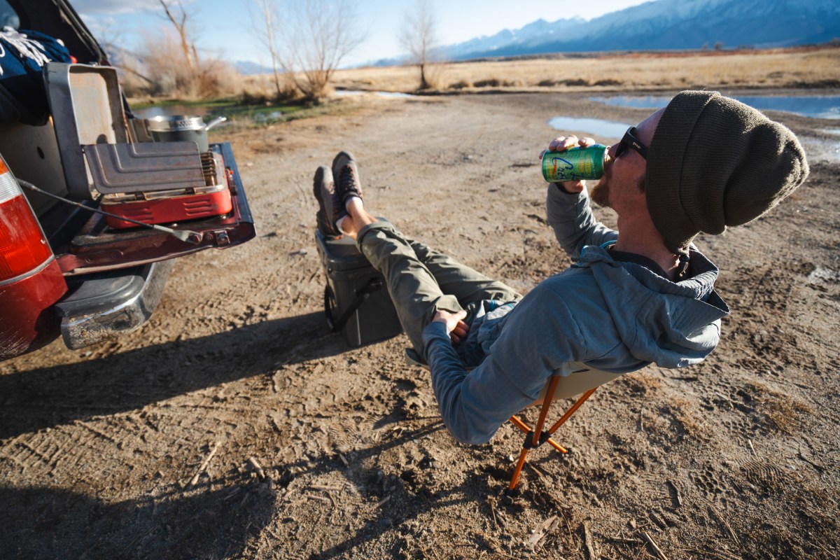 a camper kicks back in the rei flexlite air chair